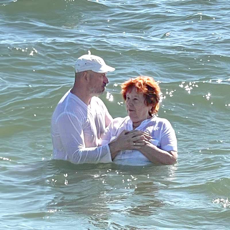 Older jewish woman beign baptized